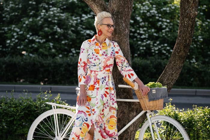 Idősebb nő csinosan felöltözve kerékpárral vélhetően férfira vár